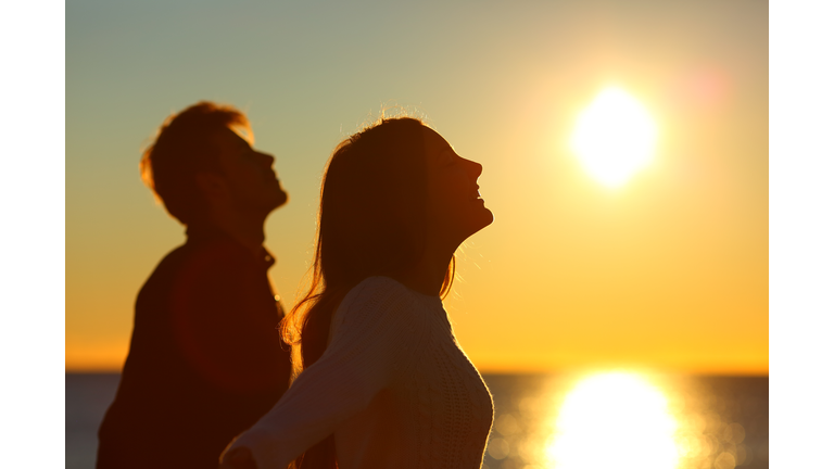 Silhouette of a couple of friends breathing at sunset