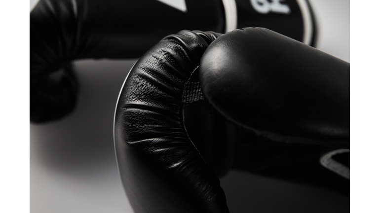 Pair of black boxing gloves on white background, closeup