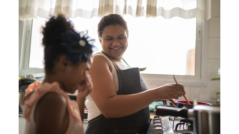 Young girl cooking with her mother