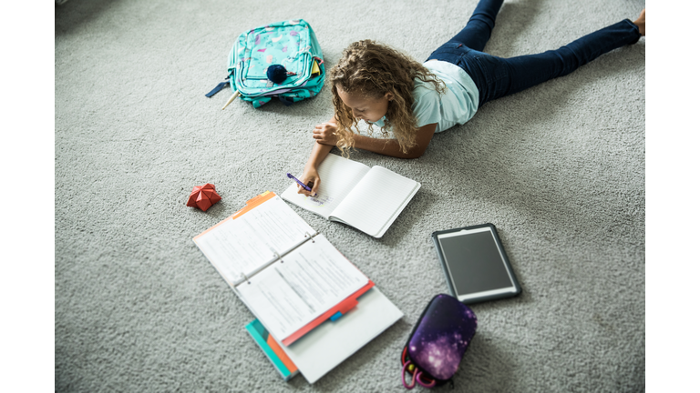 Young girl doing schoolwork in her bedroom