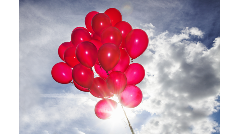 Bunch of red balloons in blue sky