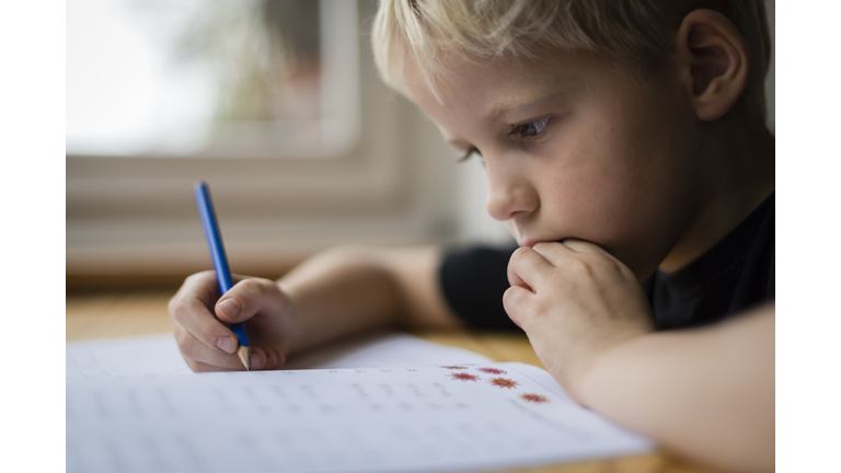 Schoolboy at his desk doing his maths homework