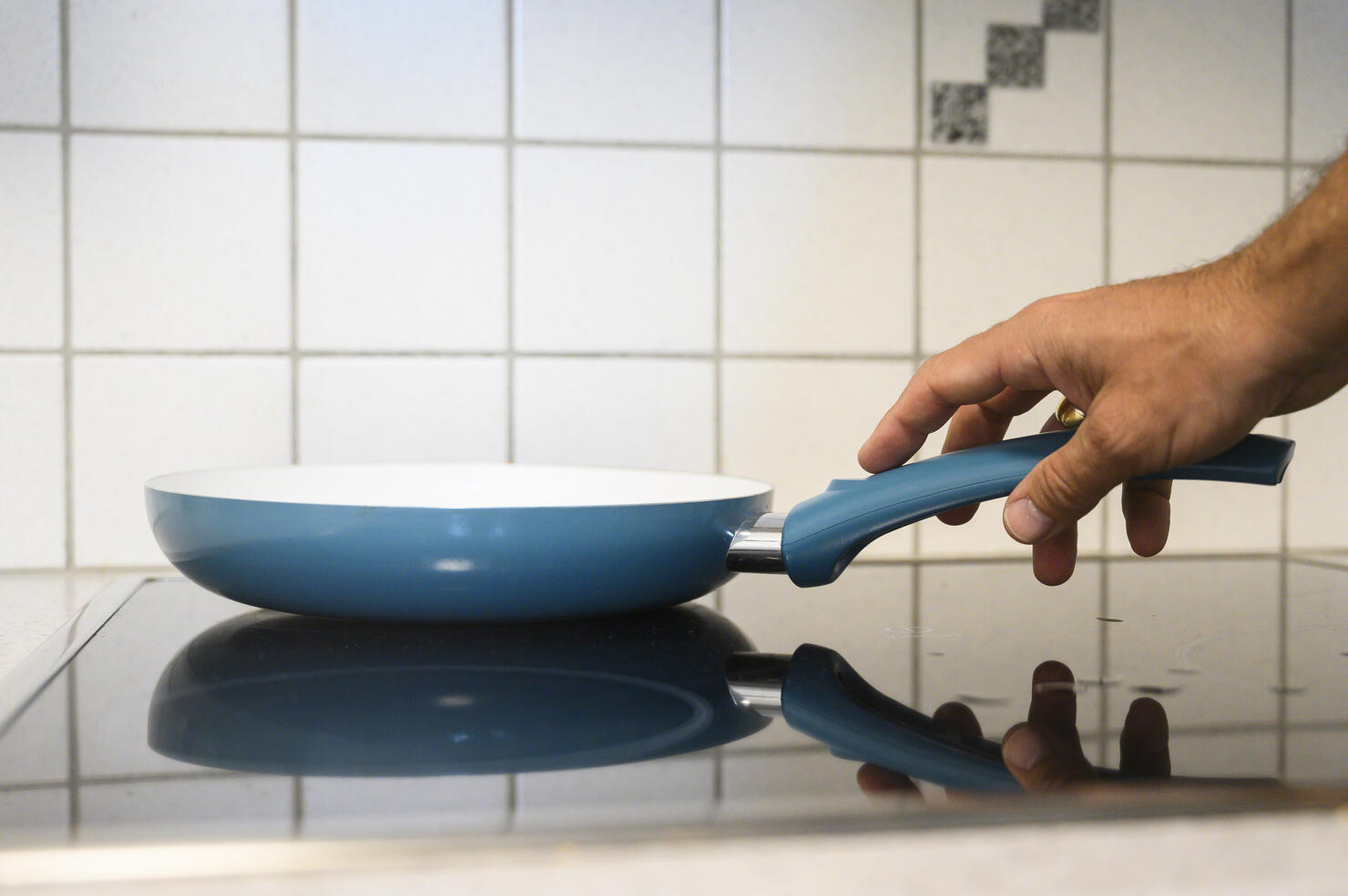 Man cooking with a frying pan in the kitchen.