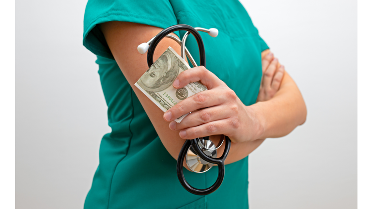 Corrupt female doctor. Nurse with money and stethoscope. The costs of medical services concept.