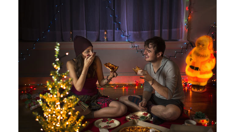 Young couple enjoying pizza at christmas
