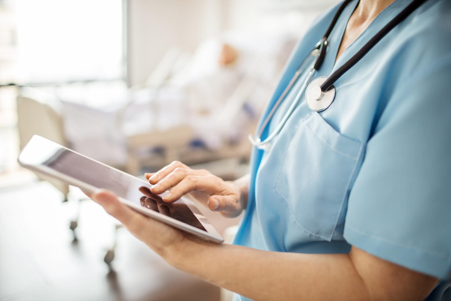 Midsection of nurse using tablet pc in hospital