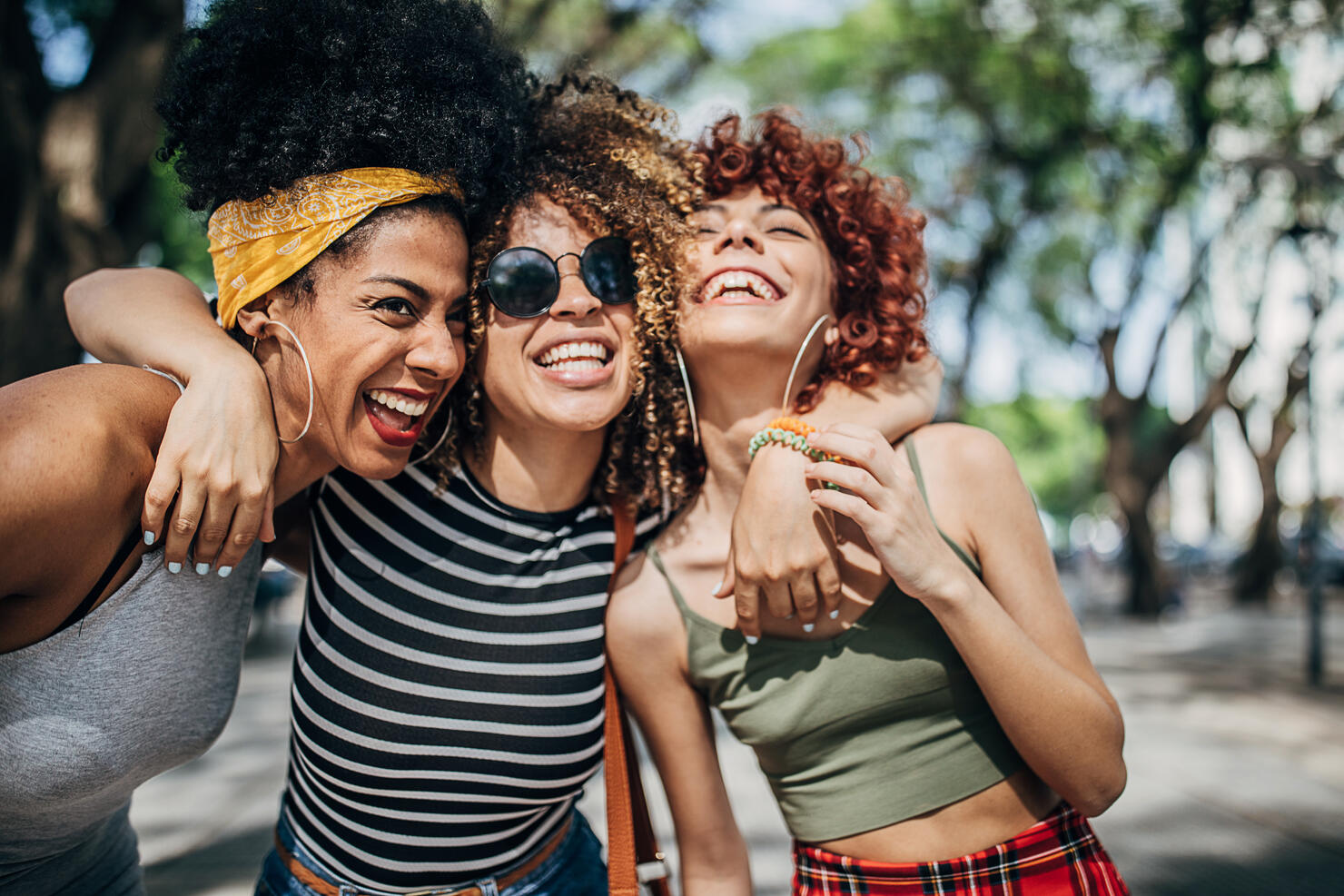 Three beautiful ladies hugging in city