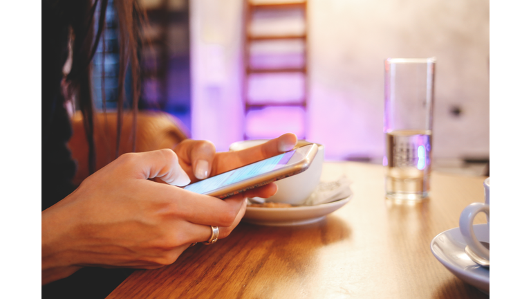 Texting on the smartphone on the coffee break