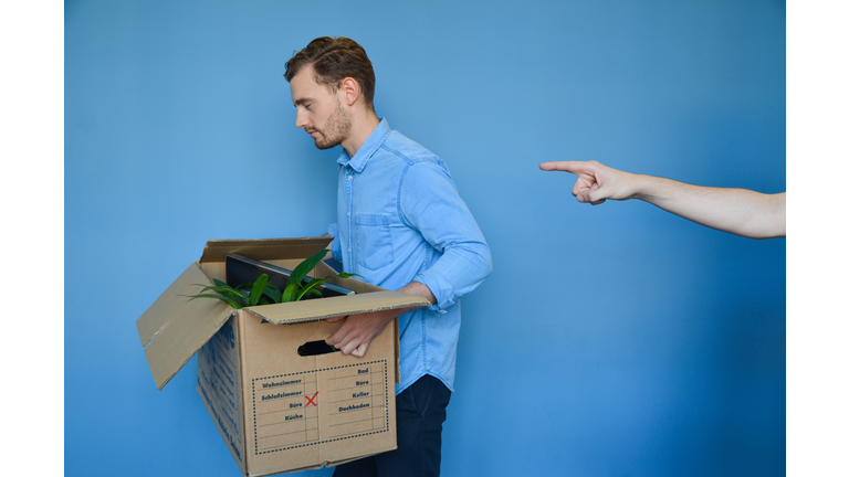 Hand Pointing At Young Man Carrying Cardboard Box After Getting Fired