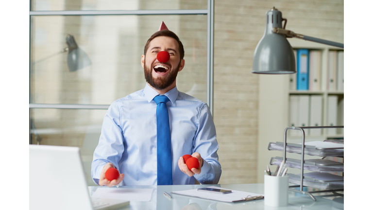 Excited businessman laughing in office