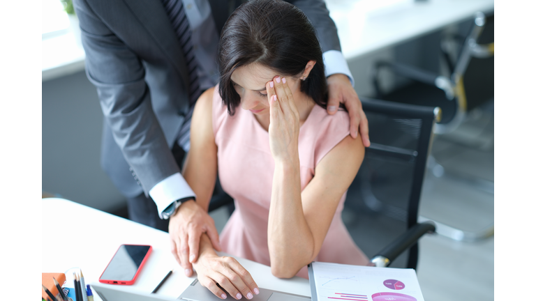 Businessman pestering female colleague in the workplace.