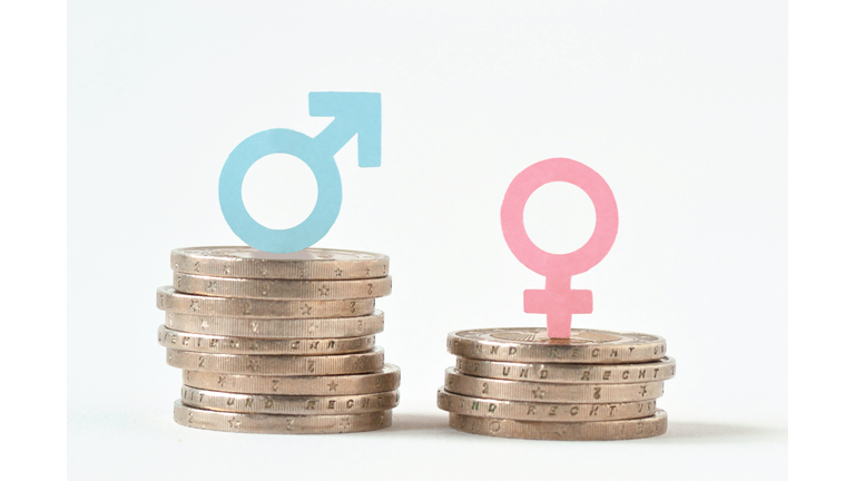 Male and female symbols on piles of coins - Gender pay equality concept