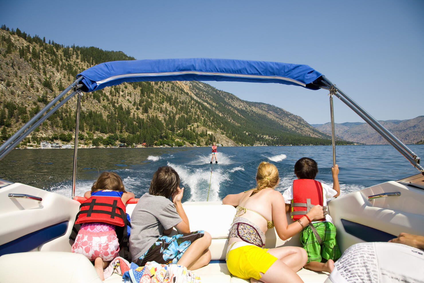 Family in a motorboat and looking at a person waterskiing, Lake Chelan, Washington State, USA
