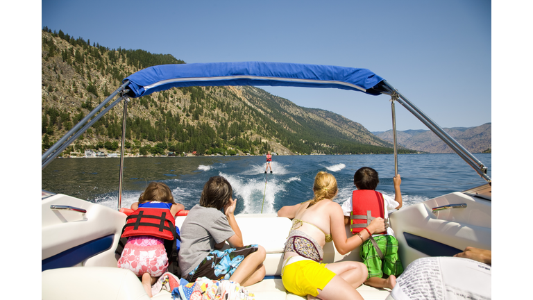 Family in a motorboat and looking at a person waterskiing, Lake Chelan, Washington State, USA