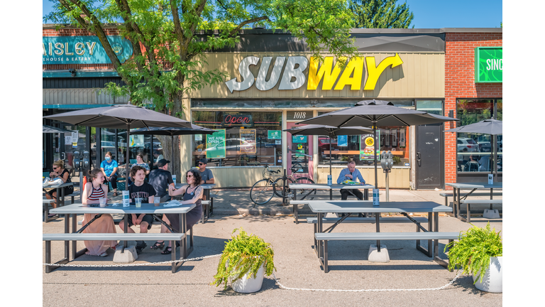 People eat outdoors on fast-food restaurant patio