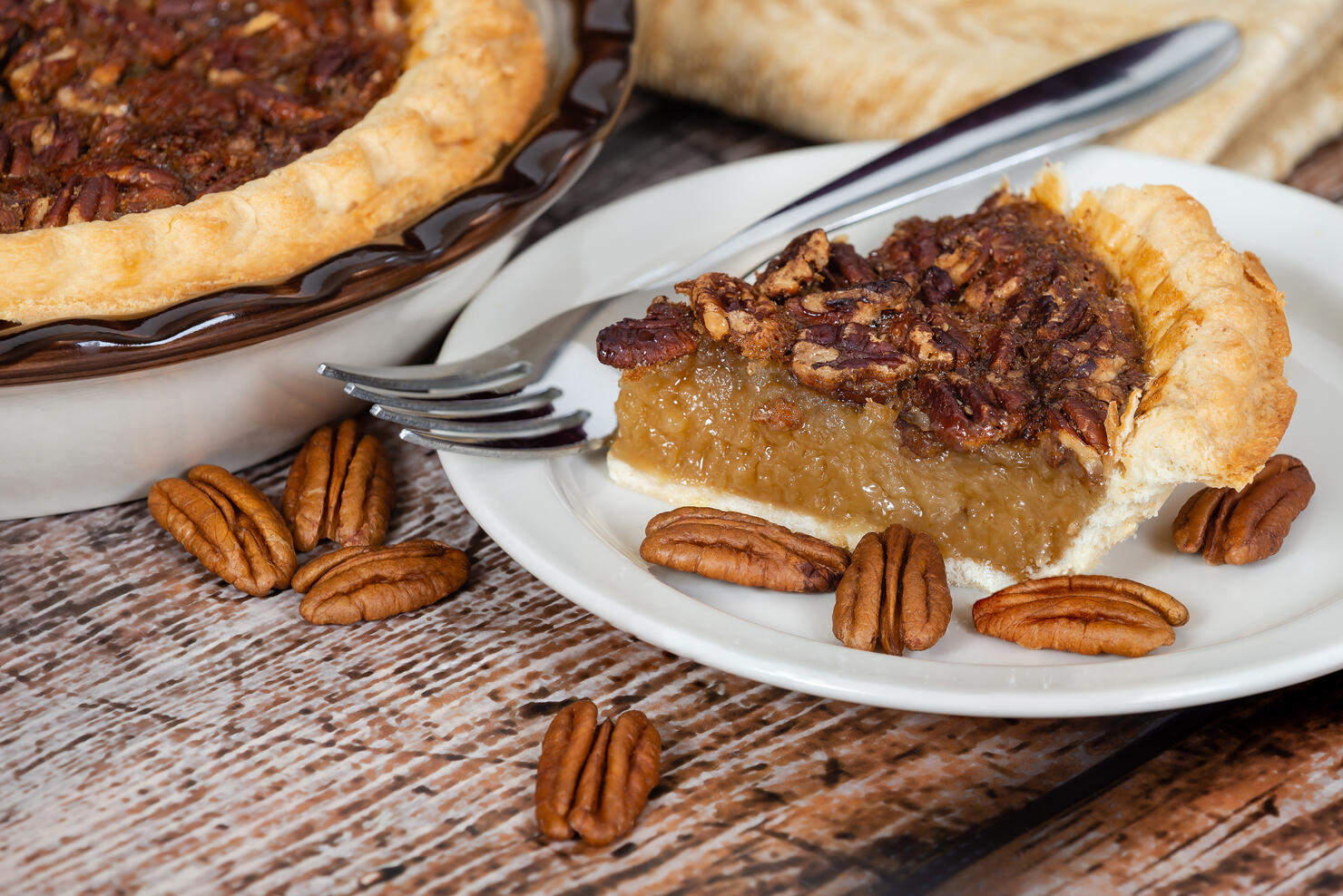 Slice of homemade pecan pie with pecans