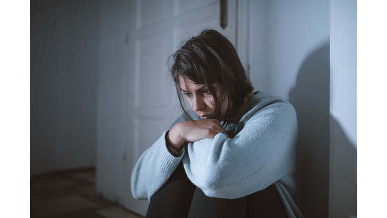 Portrait Of Young Depressed Suicidal Woman Sitting On The Floor