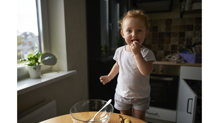 Portrait of cute toddler girl in kitchen at home