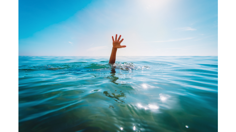 kids water safety concept- child hand see at sea, calling for help