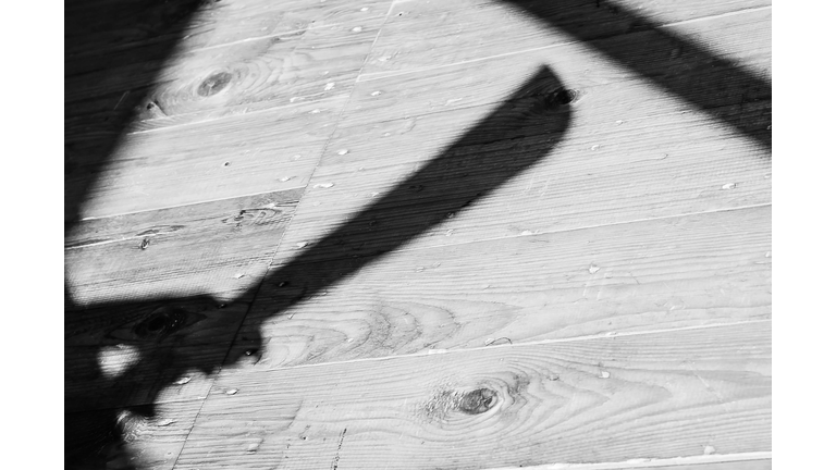 a shadow of a hand holding bid machete knife