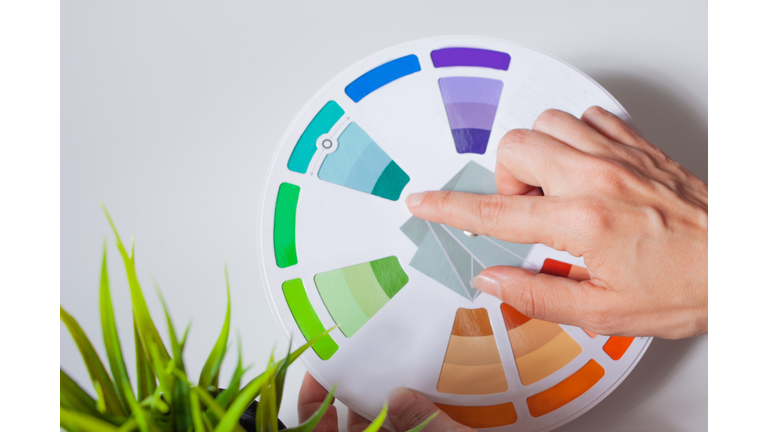 Define your color type. Female hands with neat, concise manicure rotate the color wheel.
