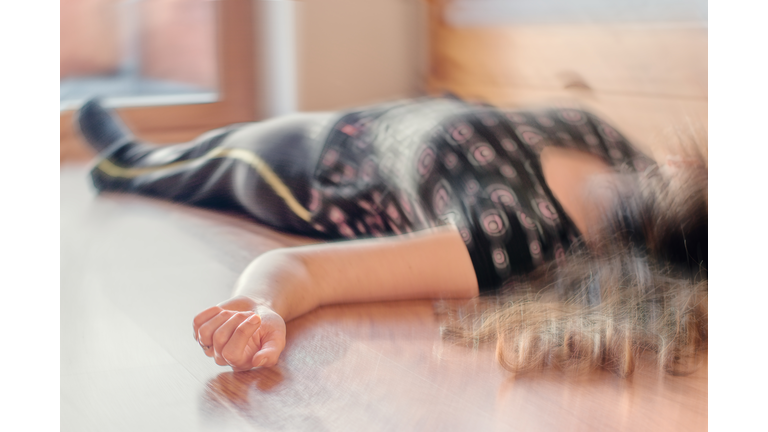 Woman lying on the floor at home, epilepsy, unconsciousness, faint, stroke, accident  or other health problem.