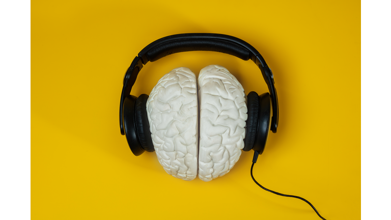 Headphones on the brain over yellow background
