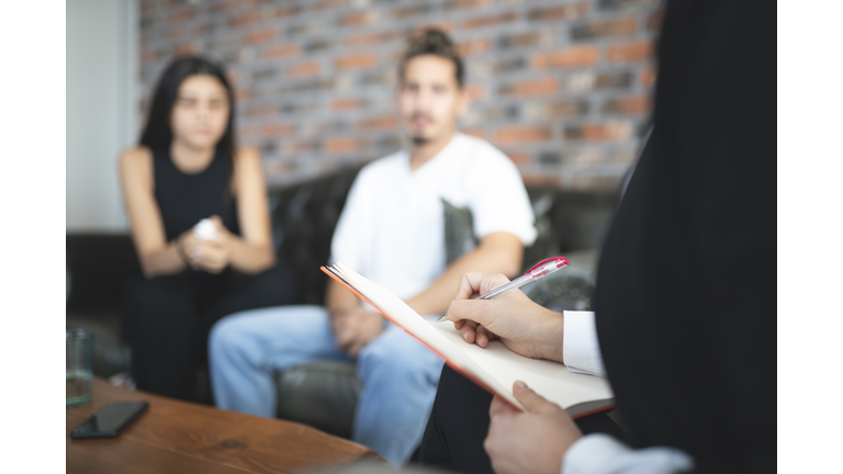 Psychologist is listening to problems of young couple