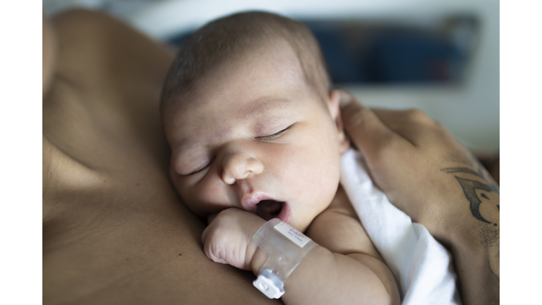 A newborn with her young mother in the hospital having a rest.