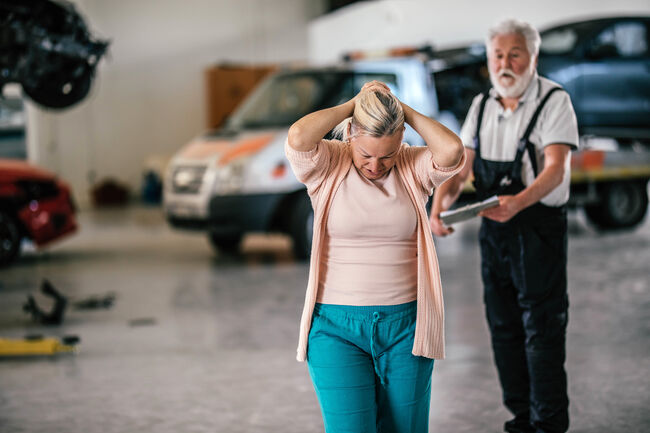 An angry customer talking to a mechanic  in an auto repair shop