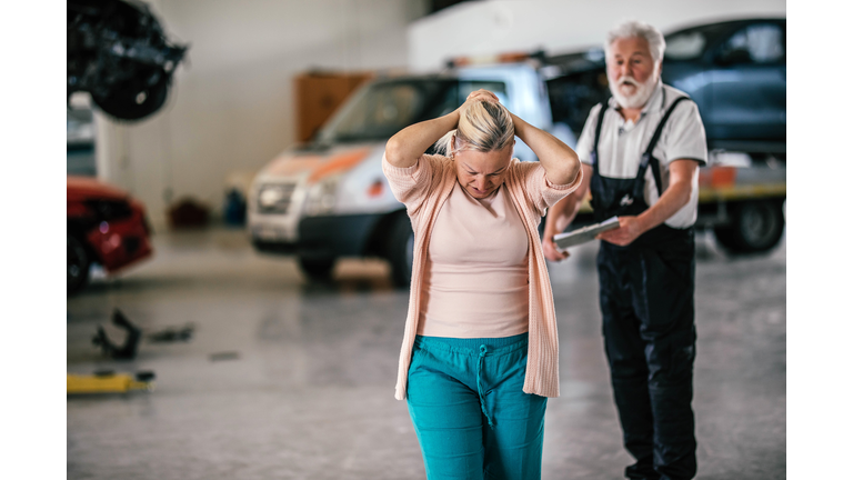 An angry customer talking to a mechanic  in an auto repair shop