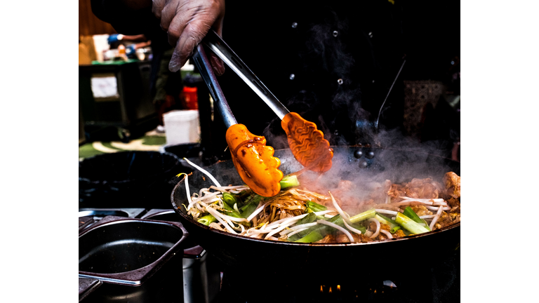 Person Holding Meat On Barbecue Grill