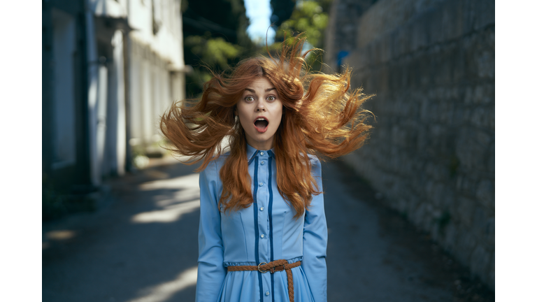 Wind blowing hair of surprised Caucasian woman