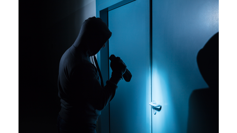 Burglar Holding Flashlight Outside The Door