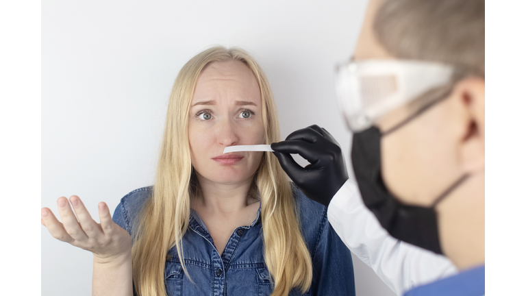 The girl complains to the doctor about the loss of smell. The doctor conducts a sense of smell test. Diagnostics of covid-19. Symptoms of the coronavirus. Quarantine and isolation. Test for sars-cov-2