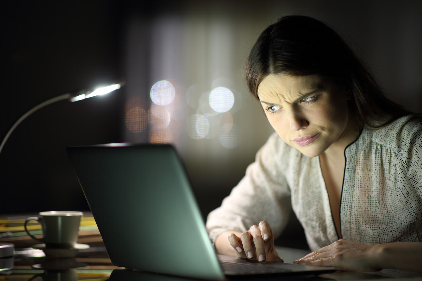 Suspicious woman checking laptop content in the night