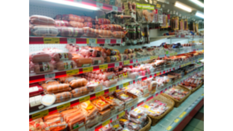 Blurred abstract image. Goods on the shelf of a grocery store. Meat and sausage products