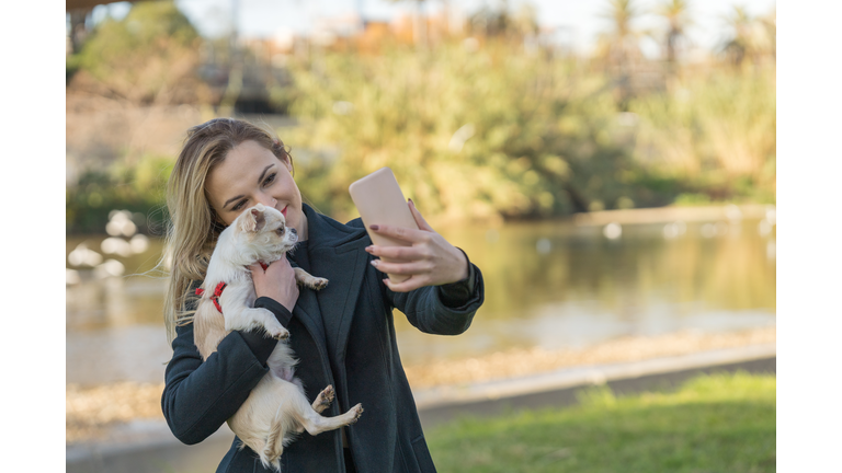 Woman takes a picture with her Chihuahua