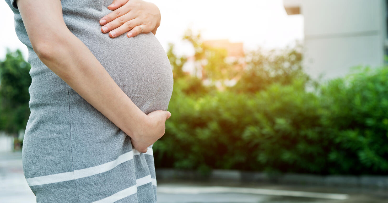 A pregnant woman touching her stomach