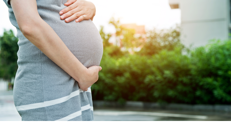 A pregnant woman touching her stomach