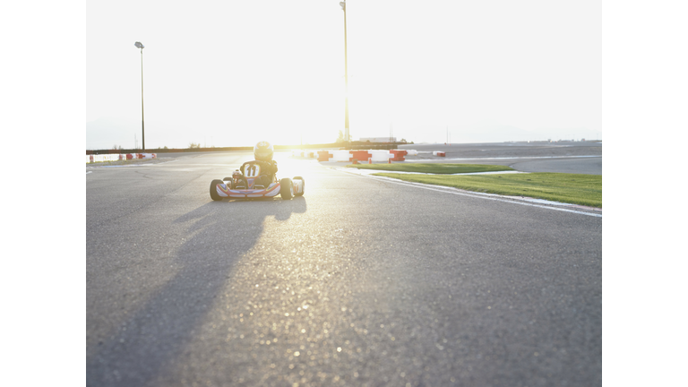 Boy (6-8) driving go-cart on track