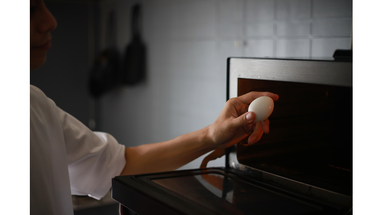 A man trying to heat an egg in the microwave