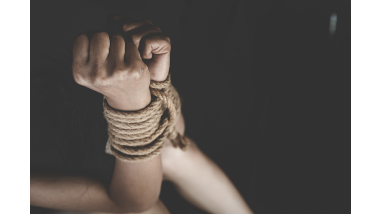 Close Of Hands Tied Up Against Black Background