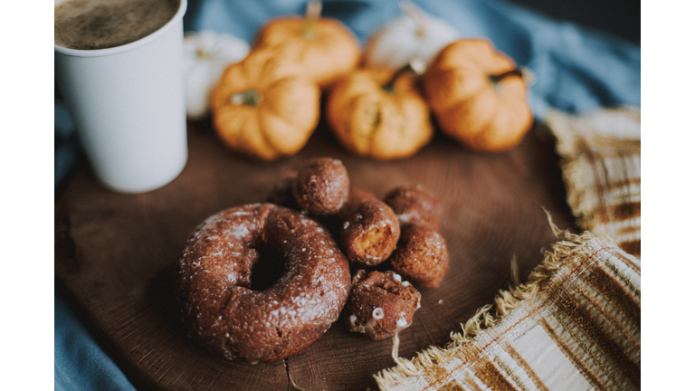 Pumpkin spice latte, pumpkin flavored snacks and a stack of pumpkins