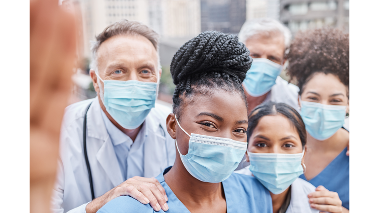 Shot of a group of doctors taking a selfie in the city