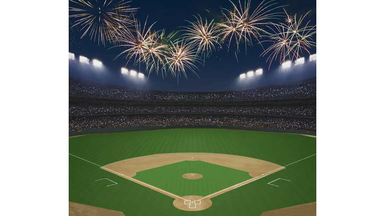 Baseball field and stadium with fireworks in sky.
