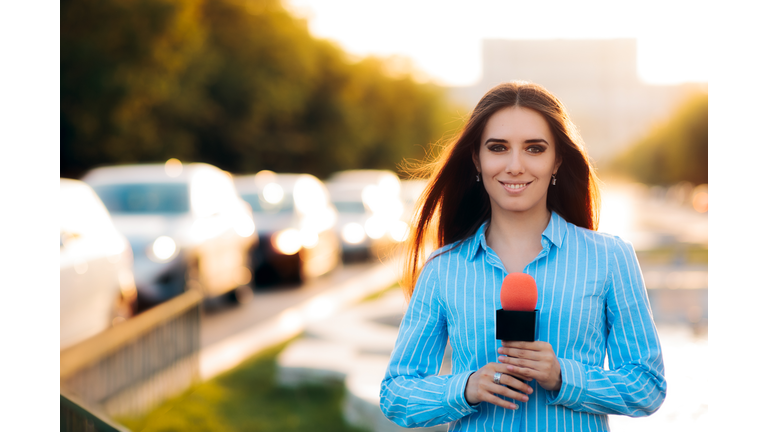 Female News Reporter on Field in Traffic