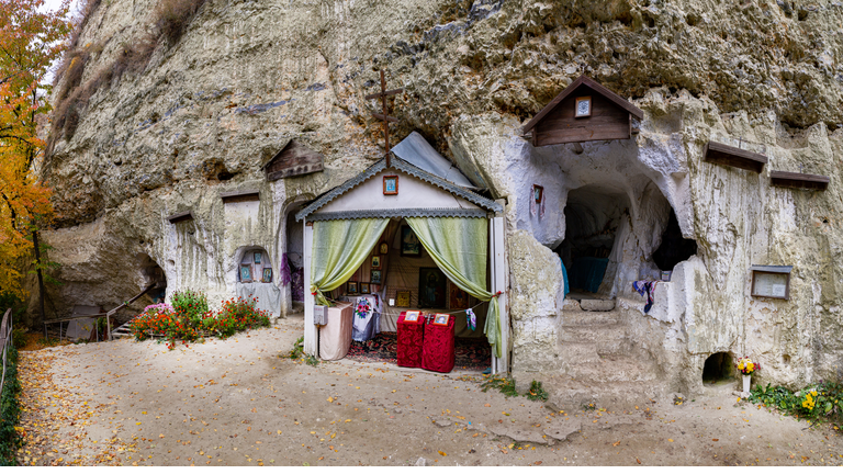 Cave monastery on Bakota over the Dniester river in autumn day.
