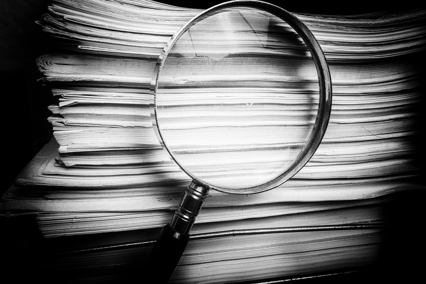 Magnify glass inspects paper documents