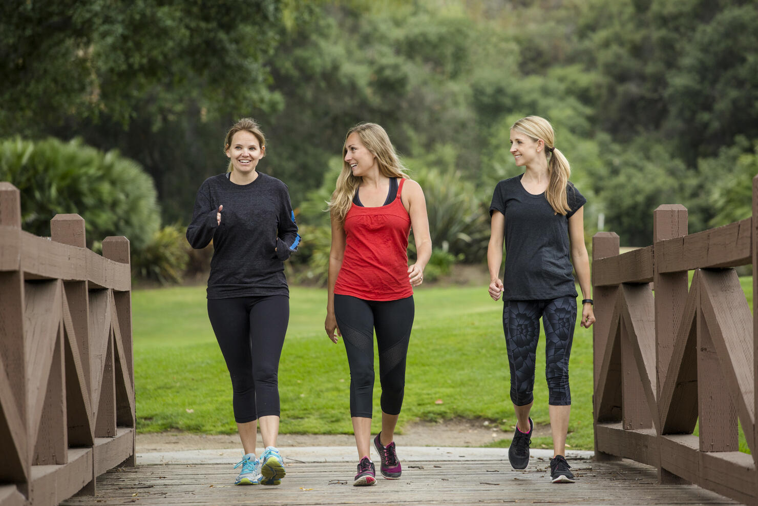 Group women in their 30s walking together in the outdoors.